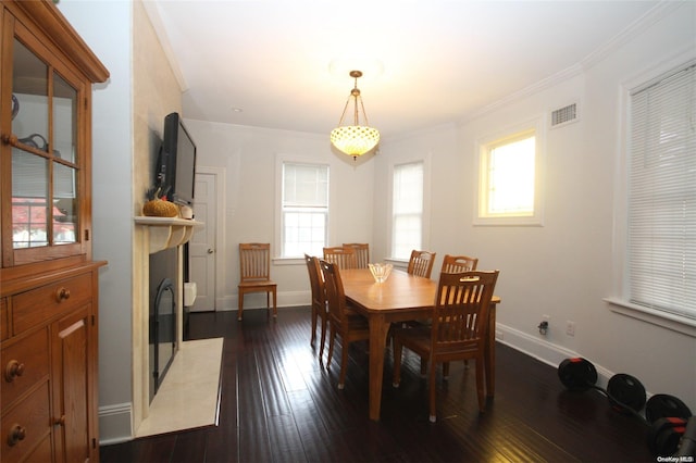 dining area featuring dark hardwood / wood-style flooring and crown molding