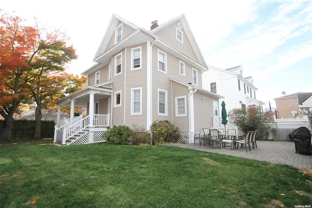 rear view of house featuring a patio area and a lawn