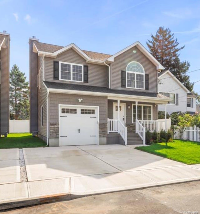 view of front of property featuring a front lawn, a porch, and a garage