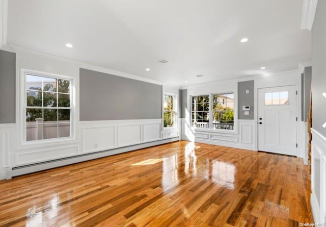 entrance foyer featuring crown molding, a baseboard radiator, and hardwood / wood-style flooring