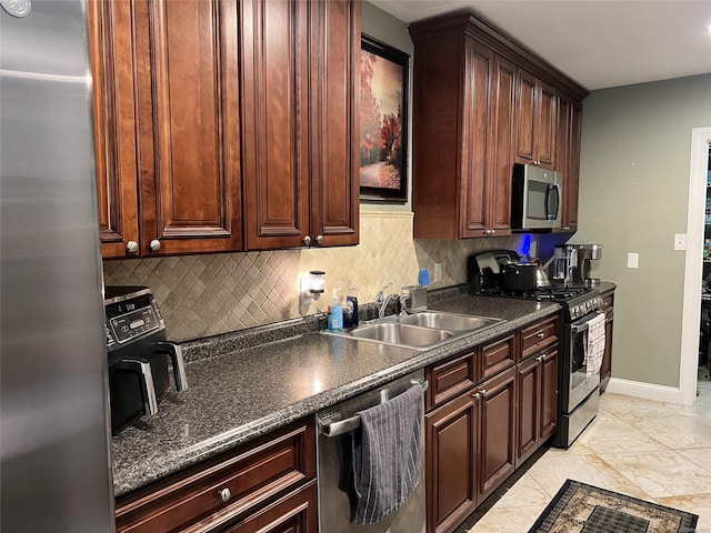 kitchen with tasteful backsplash, appliances with stainless steel finishes, and sink