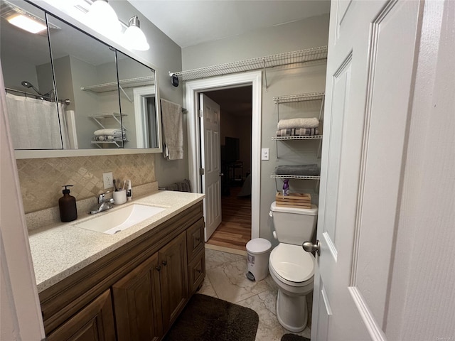 bathroom with vanity, toilet, curtained shower, and decorative backsplash