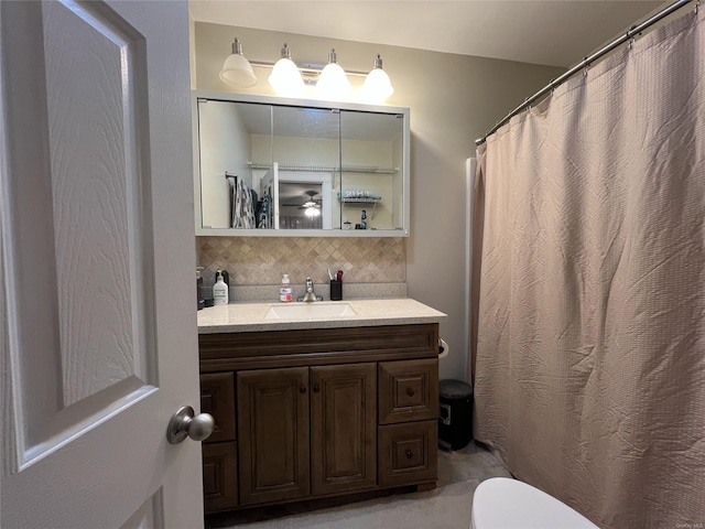 bathroom with vanity, backsplash, and toilet