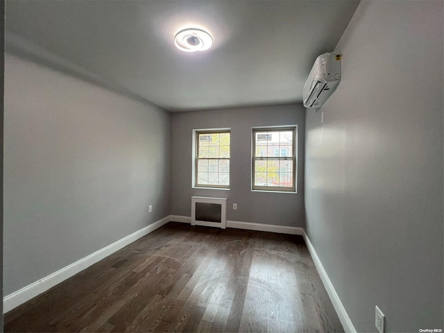 empty room with dark hardwood / wood-style floors and a wall mounted air conditioner