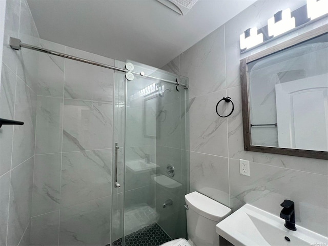 bathroom with vanity, toilet, tile walls, tasteful backsplash, and a shower with shower door