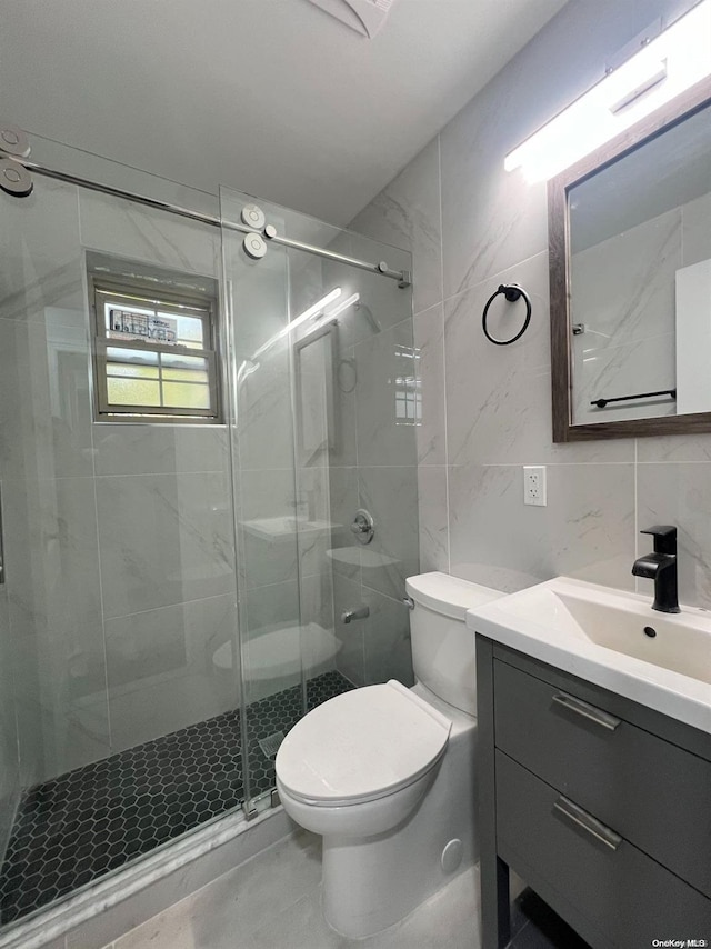 bathroom with toilet, decorative backsplash, a shower with door, vanity, and tile walls