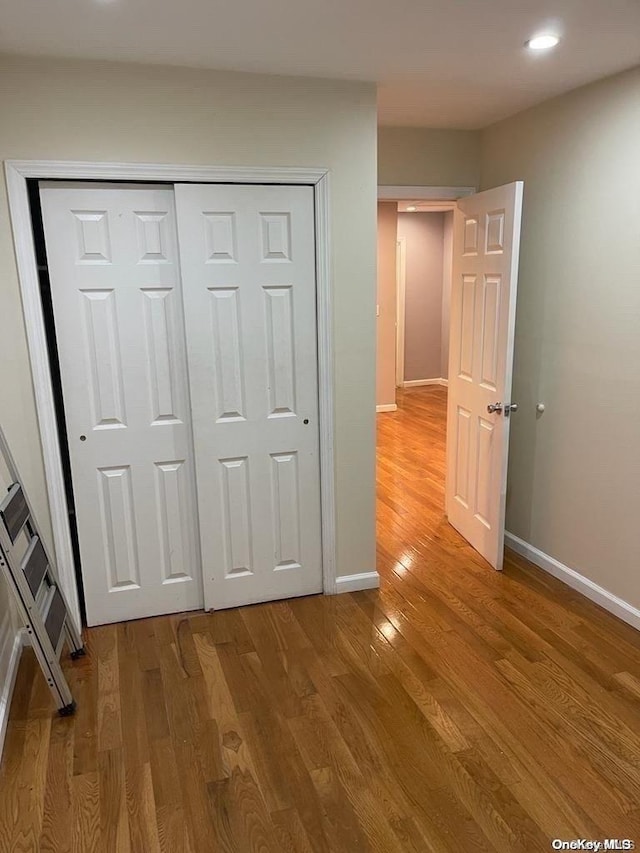 unfurnished bedroom with wood-type flooring and a closet