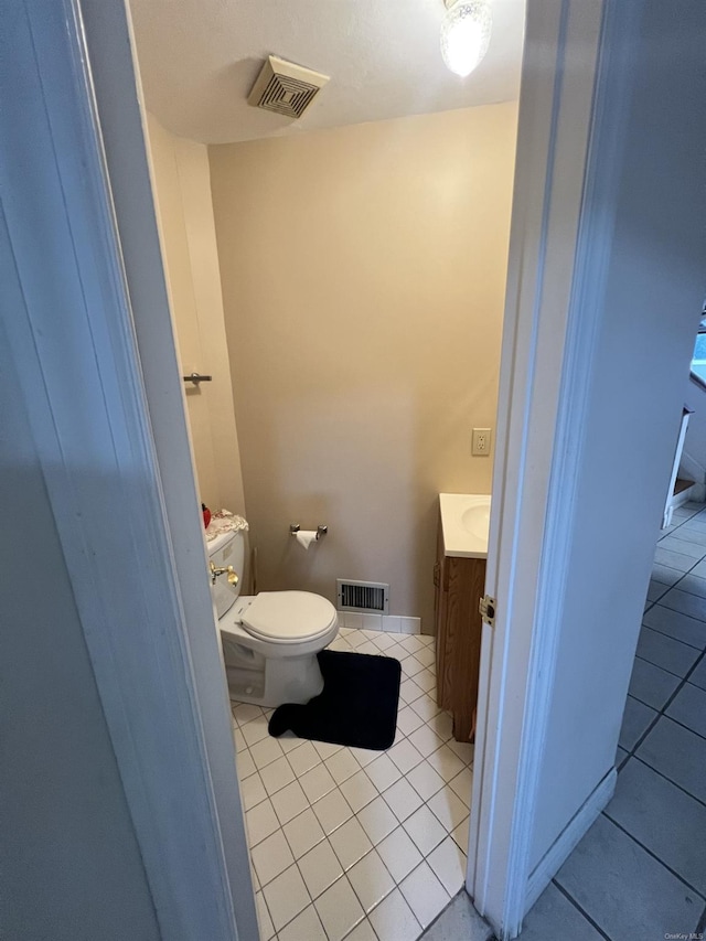 bathroom with tile patterned flooring, vanity, and toilet