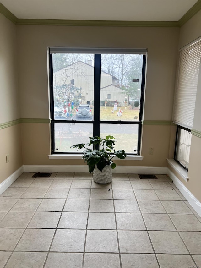 sitting room featuring light tile patterned floors, a wealth of natural light, and crown molding