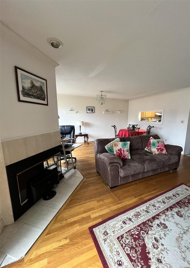 living room featuring a fireplace, hardwood / wood-style flooring, and crown molding