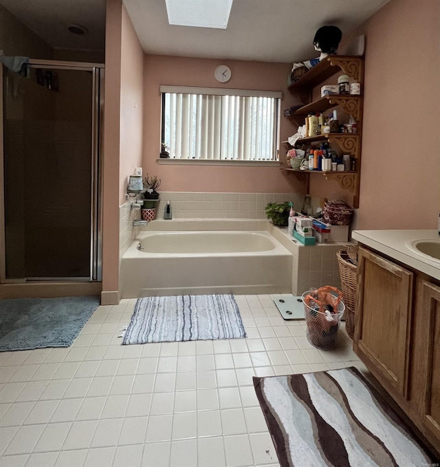 bathroom featuring tile patterned flooring, vanity, independent shower and bath, and a skylight