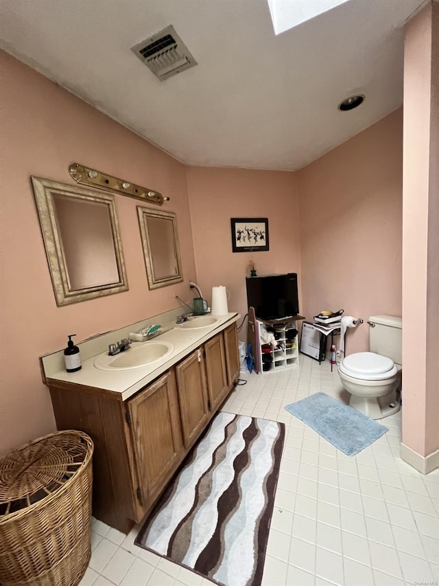 bathroom featuring tile patterned flooring, vanity, and toilet