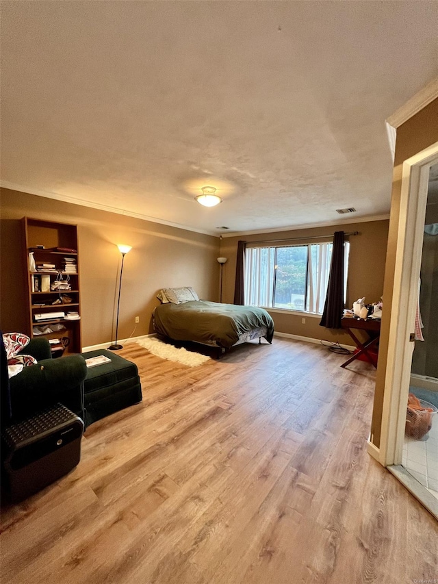 bedroom featuring wood-type flooring, a textured ceiling, and ornamental molding