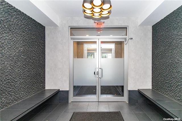 mudroom with dark tile patterned floors