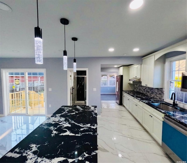 kitchen featuring white cabinets, stainless steel appliances, plenty of natural light, and sink