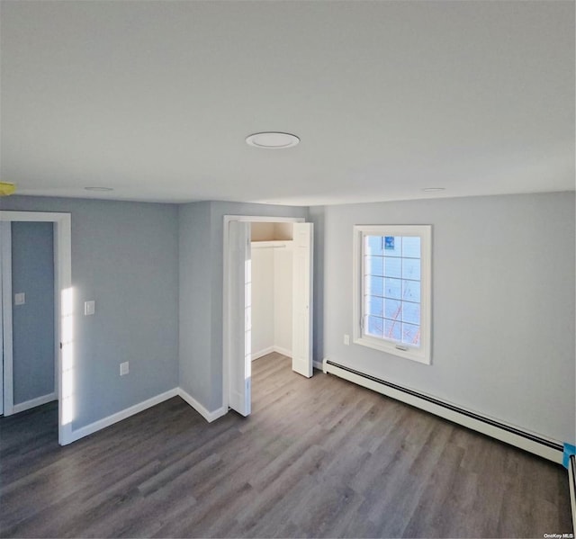 unfurnished room with a baseboard radiator and hardwood / wood-style flooring