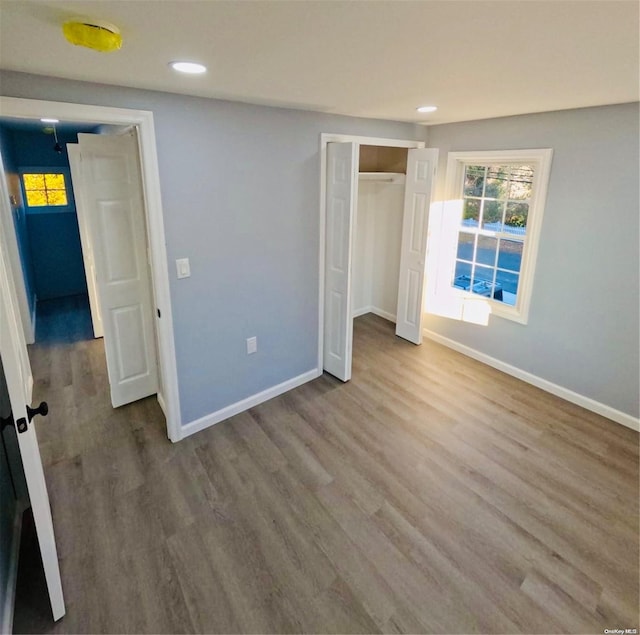 unfurnished bedroom with a closet and hardwood / wood-style floors