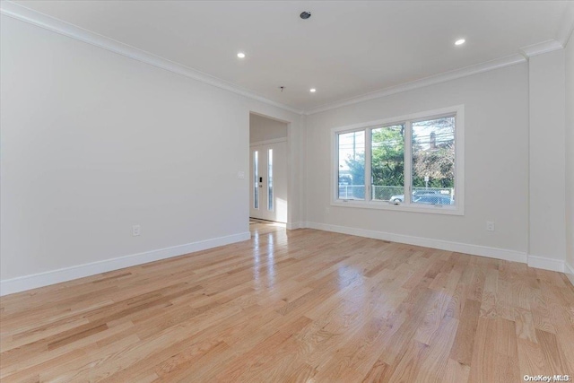 spare room featuring light hardwood / wood-style flooring and crown molding