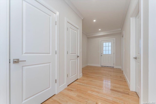 hall featuring ornamental molding and light hardwood / wood-style flooring