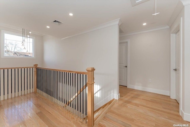 hall with ornamental molding and light hardwood / wood-style flooring