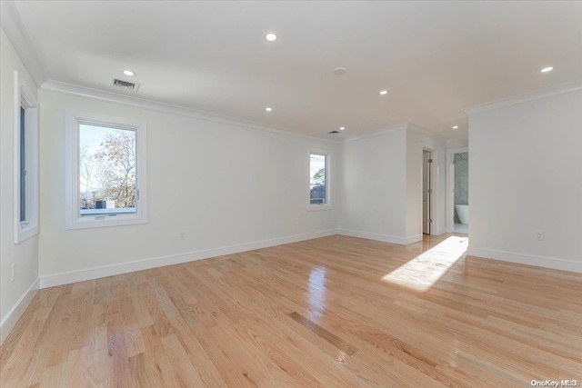 empty room featuring light hardwood / wood-style floors and crown molding