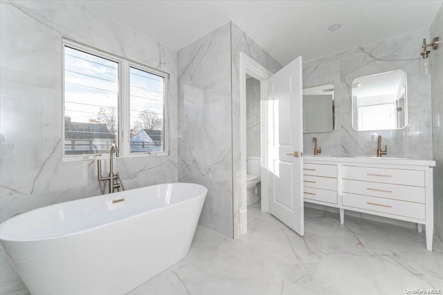 bathroom featuring a tub to relax in, vanity, and tile walls