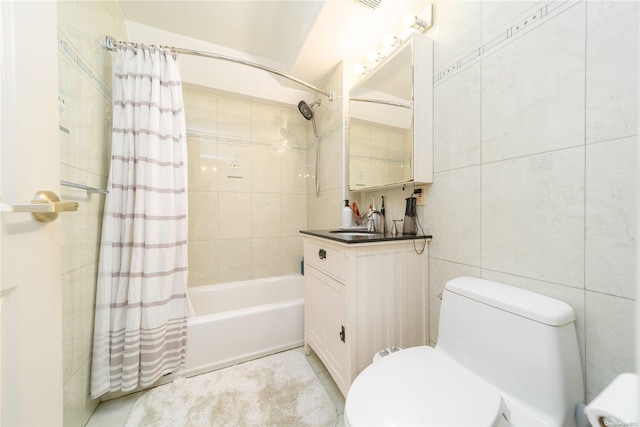 full bathroom with shower / tub combo, tile patterned flooring, toilet, vanity, and tile walls