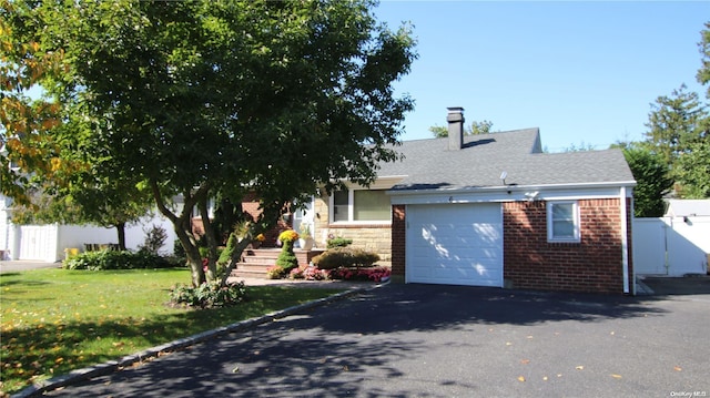 view of front of property featuring a front lawn and a garage