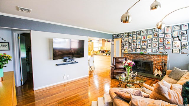 living room featuring a fireplace, wood-type flooring, and ornamental molding