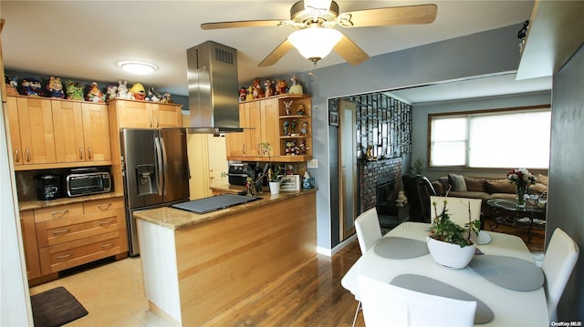 kitchen with ceiling fan, stainless steel refrigerator with ice dispenser, light hardwood / wood-style floors, black electric cooktop, and island range hood