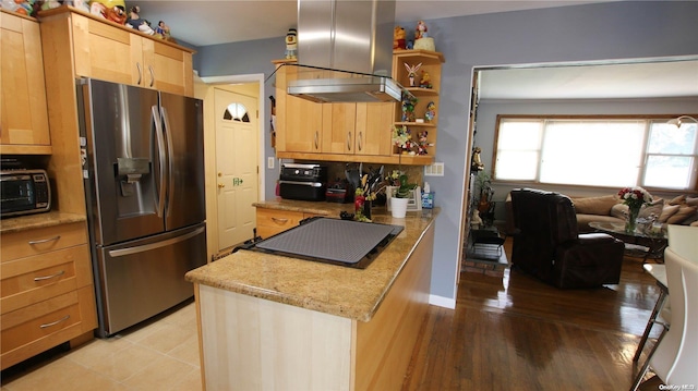 kitchen with light stone countertops, stainless steel fridge, light wood-type flooring, extractor fan, and light brown cabinets