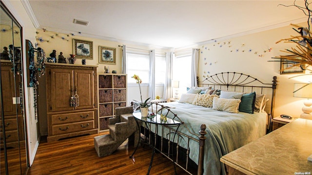 bedroom with dark hardwood / wood-style floors and ornamental molding