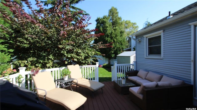 deck with an outdoor living space and a storage shed