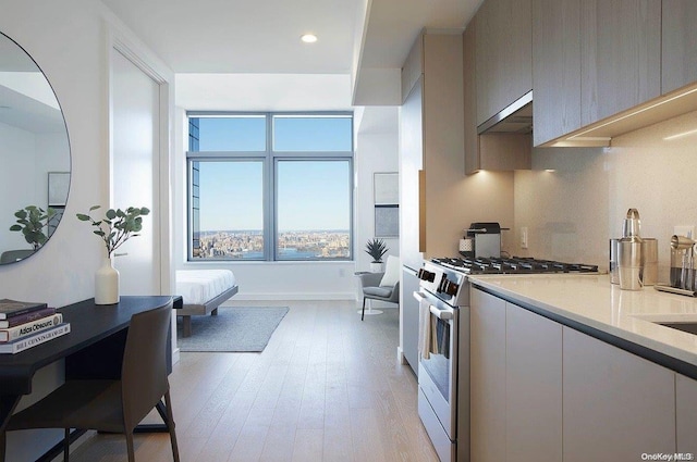 kitchen with light wood-type flooring, exhaust hood, and gas range