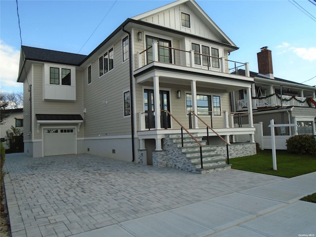 view of front of home featuring a porch, a garage, and a balcony