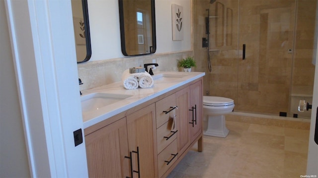 bathroom with vanity, a shower with door, toilet, and tile walls