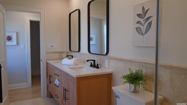 bathroom featuring hardwood / wood-style floors, vanity, toilet, and tile walls