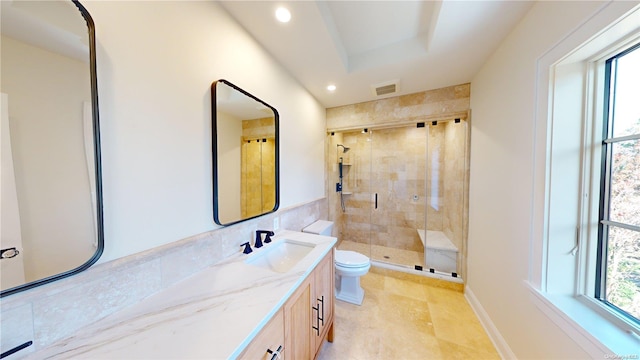 bathroom featuring a shower with door, vanity, a healthy amount of sunlight, and toilet