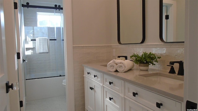80 Albany Blvd, Atlantic Beach, NY 11509 - bathroom featuring tile walls, double vanity, combined bath / shower with glass door, toilet, and a wainscoted wall