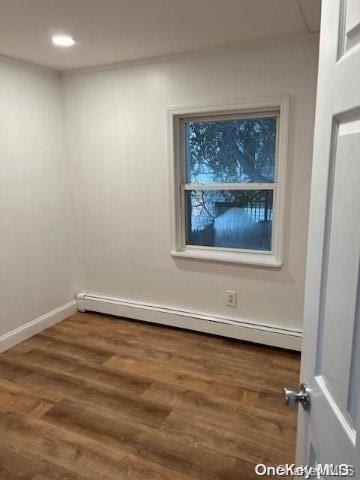 59 Port Washington Ave, Sound Beach, NY 11789 - empty room with a baseboard heating unit, wood finished floors, and baseboards