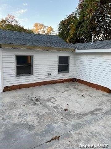 59 Port Washington Ave, Sound Beach, NY 11789 - back of house featuring a patio and roof with shingles