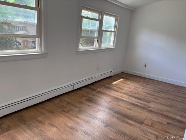 59 Port Washington Ave, Sound Beach, NY 11789 - spare room with baseboard heating, wood finished floors, and baseboards