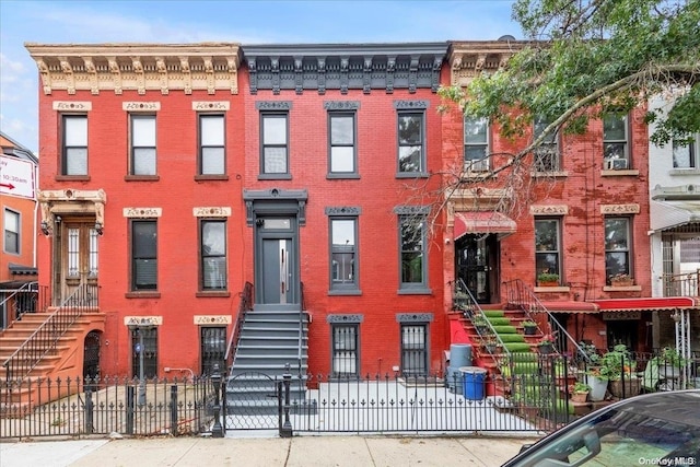 448 Halsey St, Stuyvesant Hts, NY 11233 - view of building exterior with a fenced front yard, stairs, and entry steps