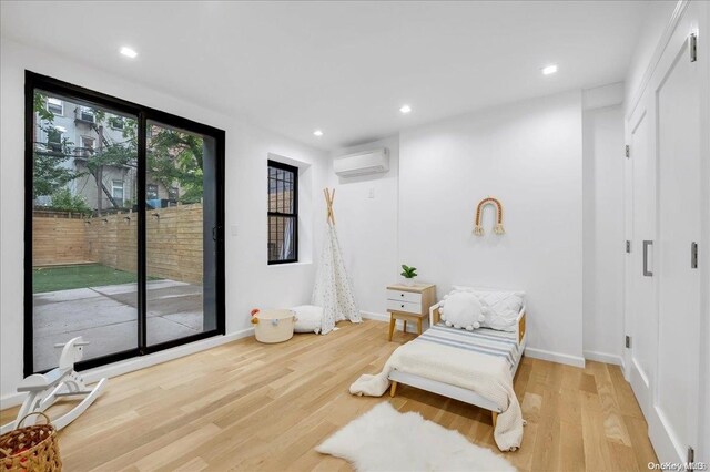 448 Halsey St, Stuyvesant Hts, NY 11233 - sitting room featuring an AC wall unit, wood finished floors, and recessed lighting