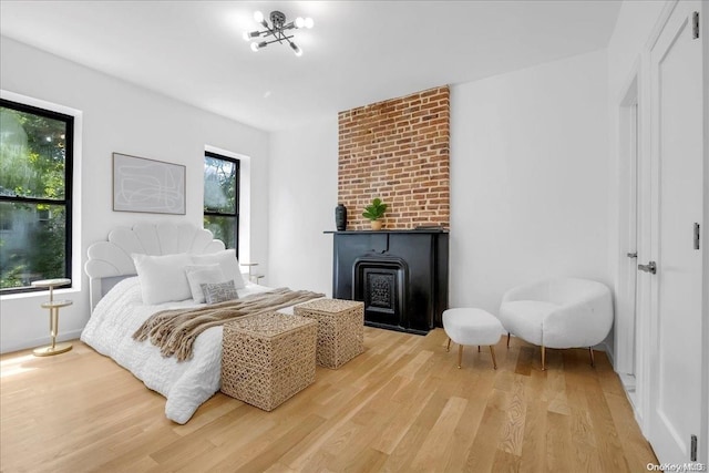 bedroom featuring light wood-type flooring and a wood stove