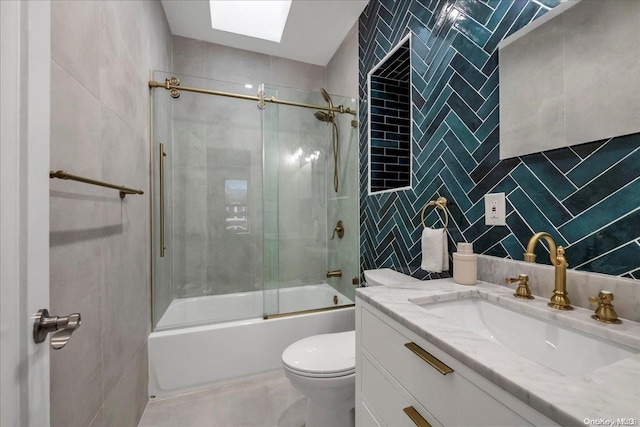 full bathroom with toilet, shower / bath combination with glass door, tile walls, and a skylight