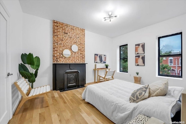 448 Halsey St, Stuyvesant Hts, NY 11233 - bedroom featuring a fireplace, light wood-style floors, and multiple windows