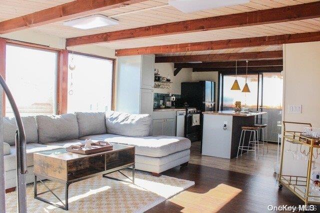 living room featuring dark hardwood / wood-style floors, beam ceiling, and wood ceiling