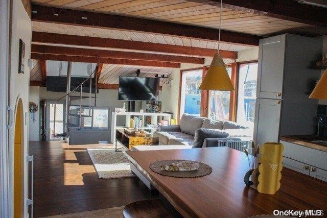 dining area featuring beam ceiling, wooden ceiling, and wood-type flooring