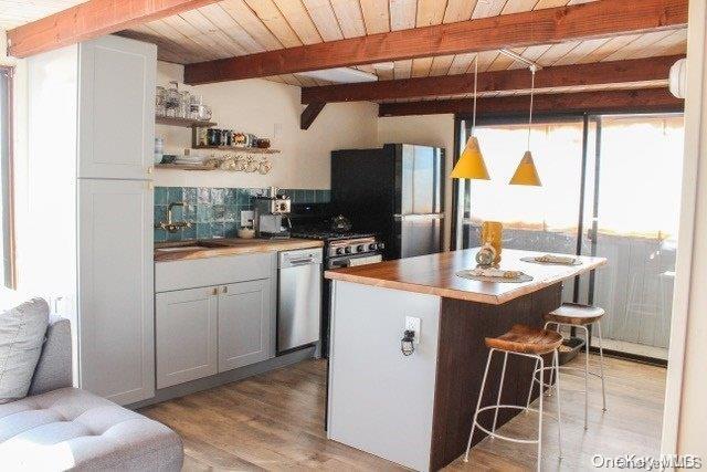 kitchen featuring decorative light fixtures, light hardwood / wood-style floors, and wood ceiling